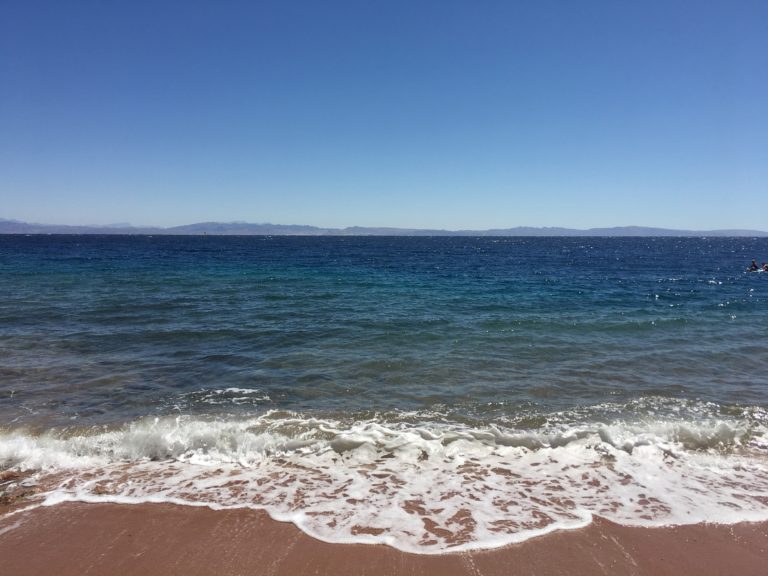 The natural beach at Fish & Friends with the sea of Dahab Bay