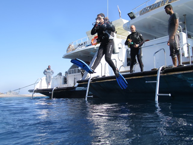 Divers stepping off the dive boat into the Red Sea